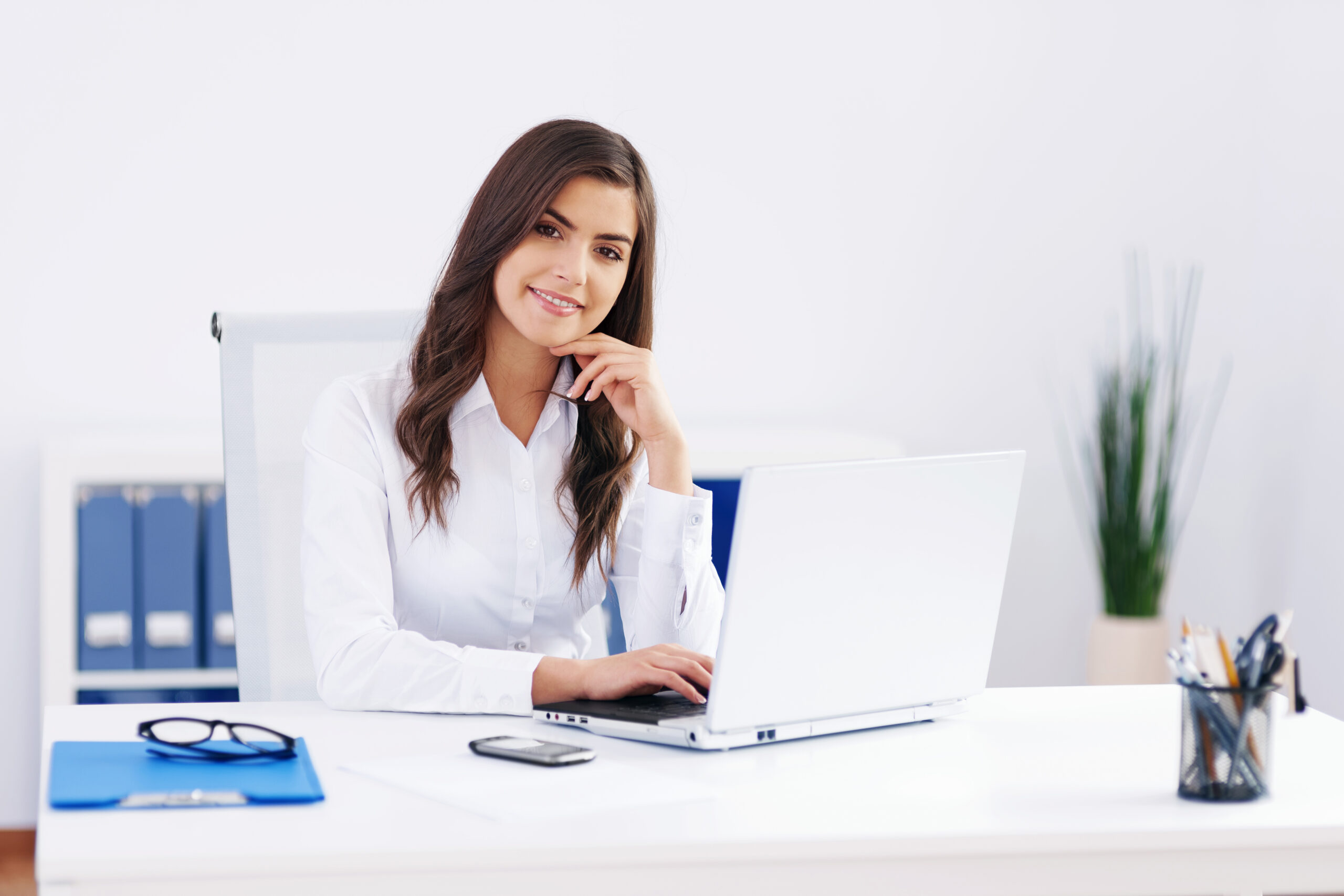 Business woman using laptop for medical billing software at modern office desk